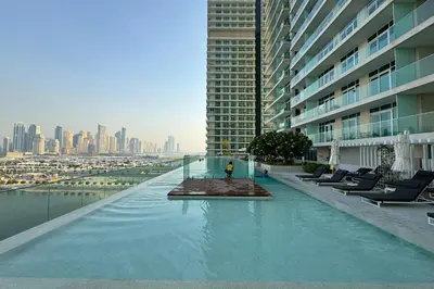a person standing on top of a swimming pool in a building at Tropical Home w Private Beach in Emaar Beachfront in Dubai
