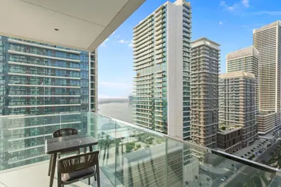 a balcony with a view of a city at Tropical Home w Private Beach in Emaar Beachfront in Dubai