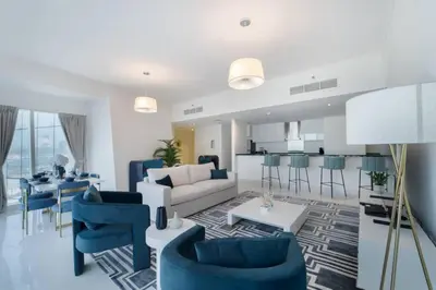 a living room with blue chairs and a couch at Blue dream apartment with Harbour view in Marina in Dubai