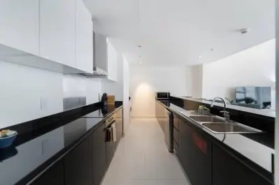 a kitchen with black and white cabinets and a sink at Blue dream apartment with Harbour view in Marina in Dubai