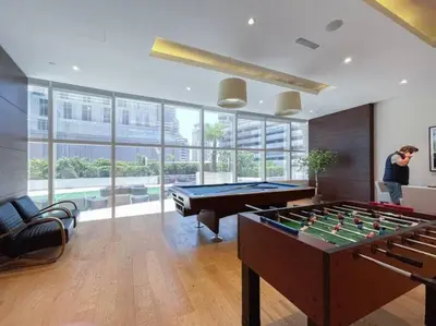 a man standing in a room with two pool tables at Blue dream apartment with Harbour view in Marina in Dubai