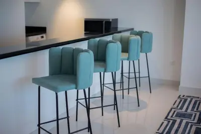 a row of blue bar stools at a counter at Blue dream apartment with Harbour view in Marina in Dubai