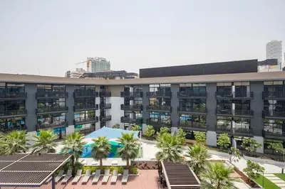 an apartment building with palm trees in front of it at Frank Porter - Belgravia 3 in Dubai