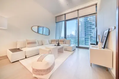 a living room with white furniture and a large window at Burj Vista, Downtown Dubai - Burj Khalifa View - Mint Stay in Dubai