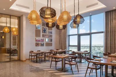 a restaurant with tables and chairs and large windows at Paramount Midtown - Fantastic 2 Bedroom Apartment with Sea View in Dubai