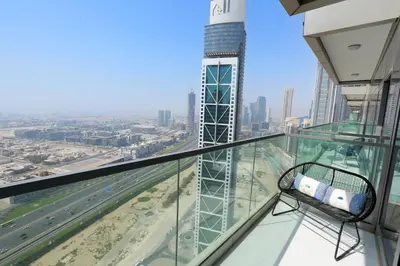 a chair on a glass balcony with a view of a city at Paramount Midtown - Fantastic 2 Bedroom Apartment with Sea View in Dubai