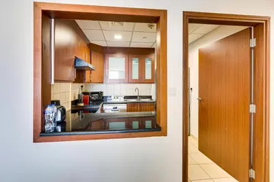 a kitchen with wooden cabinets and a view of a sink at Wonderful 2BD apartment near The Beach Sadaf Jbr in Dubai