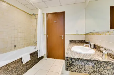 a bathroom with a sink and a bath tub and a mirror at Wonderful 2BD apartment near The Beach Sadaf Jbr in Dubai