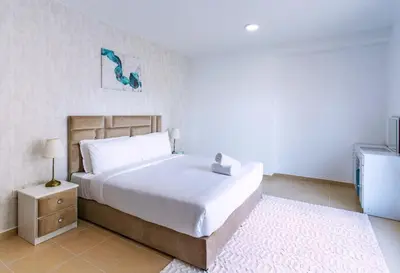 a bedroom with a large white bed and a night stand at Spacious 2 BR with Amazing Marina View Rimal JBR in Dubai