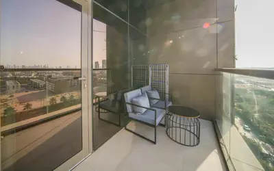 a balcony with a chair and a view of a city at Big Modern Studio in Park View JVC in Dubai