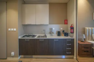 a small kitchen with a sink and a stove at Big Modern Studio in Park View JVC in Dubai