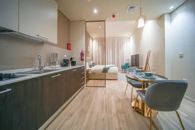 a kitchen and dining room with a table and chairs at Big Modern Studio in Park View JVC in Dubai