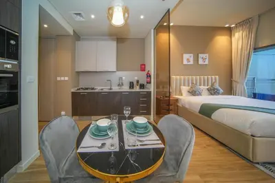 a bedroom with a bed and a table and chairs at Big Modern Studio in Park View JVC in Dubai