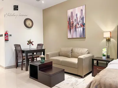 a living room with a couch and a table at Mira Holiday Homes - Newly furnished studio in Downtown in Dubai