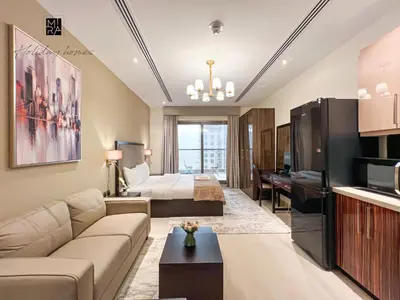a living room with a couch and a bed at Mira Holiday Homes - Newly furnished studio in Downtown in Dubai