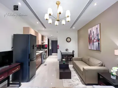 a living room with a couch and a table at Mira Holiday Homes - Newly furnished studio in Downtown in Dubai