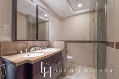 a bathroom with two sinks and a glass shower at LUX - The Downtown Blvd Suite in Dubai