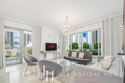 a living room with a couch and chairs and windows at LUX - The Downtown Blvd Suite in Dubai