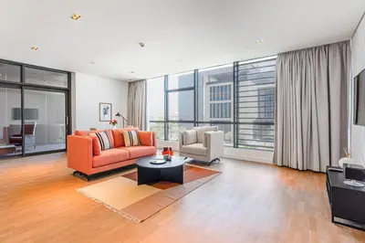 a living room with an orange couch and a chair at Vonder: City Walk in Dubai