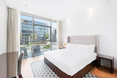 a bedroom with a white bed and a large window at Vonder: City Walk in Dubai
