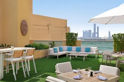 a patio with tables and chairs and a view of the city at Marriott Executive Apartments Al Jaddaf, Dubai in Dubai