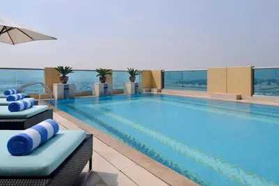 a large swimming pool with two lounge chairs in a hotel at Marriott Executive Apartments Al Jaddaf, Dubai in Dubai