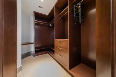 a walk in closet with wooden cabinets and wine racks at EDEN'S Homes & Villas - Opera Grand in Dubai