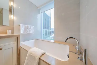 a white bathroom with a sink and a window at EDEN'S Homes & Villas - Opera Grand in Dubai