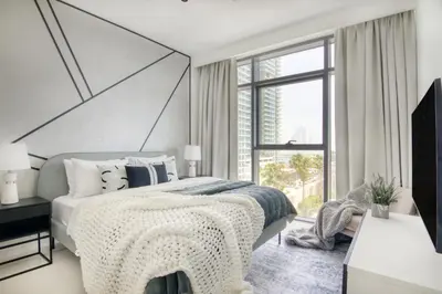a bedroom with a large bed and a large window at The Smart Concierge - Beach Vista 2 in Dubai