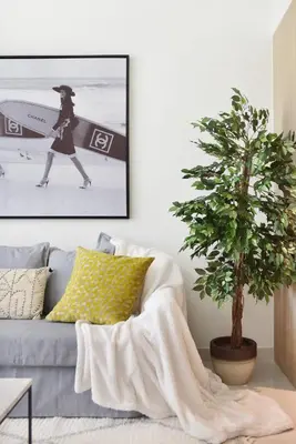 a living room with a couch and a tree at The Smart Concierge - Beach Vista 2 in Dubai