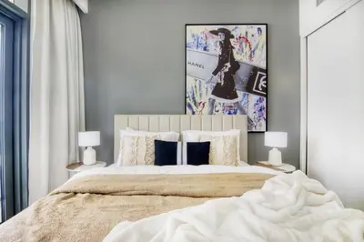 a bedroom with a large bed with two lamps at The Smart Concierge - Beach Vista 2 in Dubai