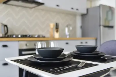 a table with two black bowls and plates on it at GuestReady - In the Heart of Dubai Hills in Dubai