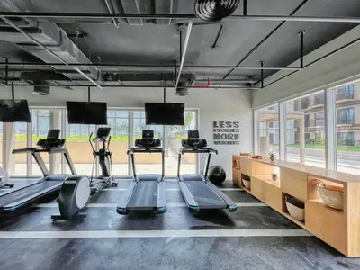 a gym with treadmills and exercise equipment and windows at GuestReady - In the Heart of Dubai Hills in Dubai