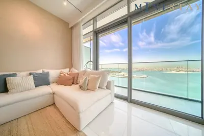 a living room with a white couch and a large window at Beach Vista 1 Emaar Beachfront - Mint Stay in Dubai