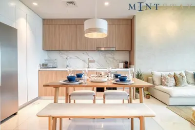 a kitchen and living room with a wooden table and chairs at Beach Vista 1 Emaar Beachfront - Mint Stay in Dubai
