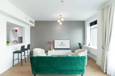 a living room with a green couch and chairs at Luxury Escapes - Full Marina View Luxury 2BR - Park Island Sanibel in Dubai
