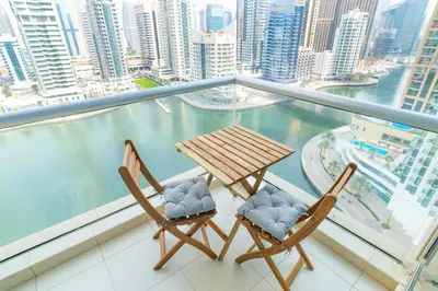 two chairs and a table on a balcony with a view at Luxury Escapes - Full Marina View Luxury 2BR - Park Island Sanibel in Dubai