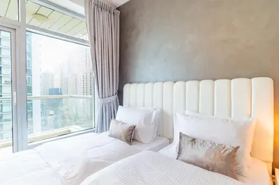 a bedroom with a white bed with a large window at Luxury Escapes - Full Marina View Luxury 2BR - Park Island Sanibel in Dubai