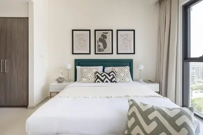 a bedroom with a large white bed and a window at Frank Porter - Park Ridge C in Dubai