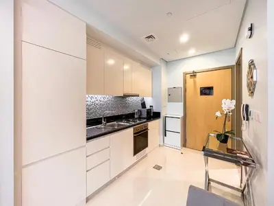 a kitchen with white cabinets and a refrigerator at Luton Vacation Homes - Damac Paramount Midtown Business Bay Dubai - 37AB09 in Dubai