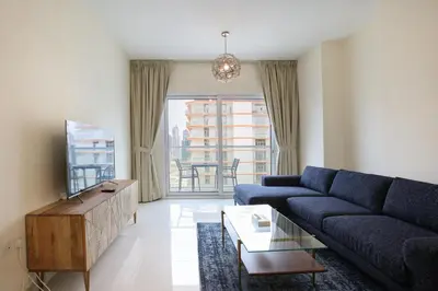 a living room with a blue couch and a table at AG Tower - 1BR Apartment - Allsopp&Allsopp in Dubai