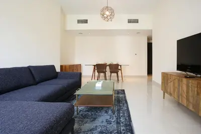 a living room with a blue couch and a table at AG Tower - 1BR Apartment - Allsopp&Allsopp in Dubai