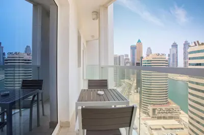 a balcony with a table and chairs and a view of the city at AG Tower - 1BR Apartment - Allsopp&Allsopp in Dubai