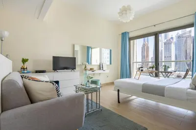 a bedroom with a bed and a couch and a window at Frank Porter - Marina Views B in Dubai