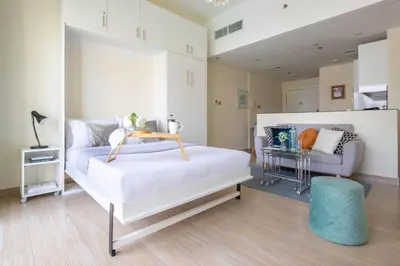 a bedroom with a white bed and a couch at Frank Porter - Marina Views B in Dubai