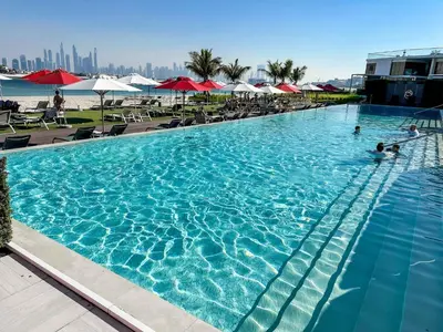 a large swimming pool with people in the water at Cozy beachfront 1 bedroom apartment - The 8 in Dubai