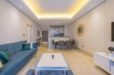 a living room with a blue couch and a table at Cozy beachfront 1 bedroom apartment - The 8 in Dubai