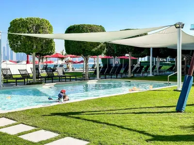 a person swimming in a swimming pool under a canopy at Cozy beachfront 1 bedroom apartment - The 8 in Dubai