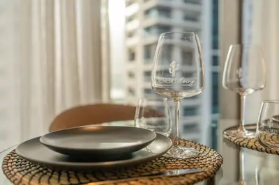 a table with a plate and wine glasses on it at Desert Living Luxury Condo - Jumeirah Living Marina Gate in Dubai