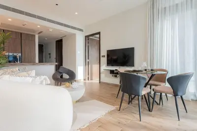 a living room with a table and chairs and a kitchen at Desert Living Luxury Condo - Jumeirah Living Marina Gate in Dubai